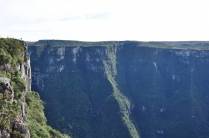 O Rodrigo (no alto, à esquerda) fica minúsculo diante da enormidade do canyon Fortaleza, em Cambará do Sul - RS